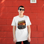 Woman wearing a white t-shirt with 'American Muscle' car graphic design in front of a red brick wall.