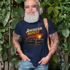 Man wearing a navy blue t-shirt with an 'American Muscle' car graphic design, standing among green plants.