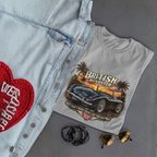 Sport gray t-shirt with 'British Roadster' graphic design, denim jacket with red heart patch, sunglasses, and necklace on gray surface.