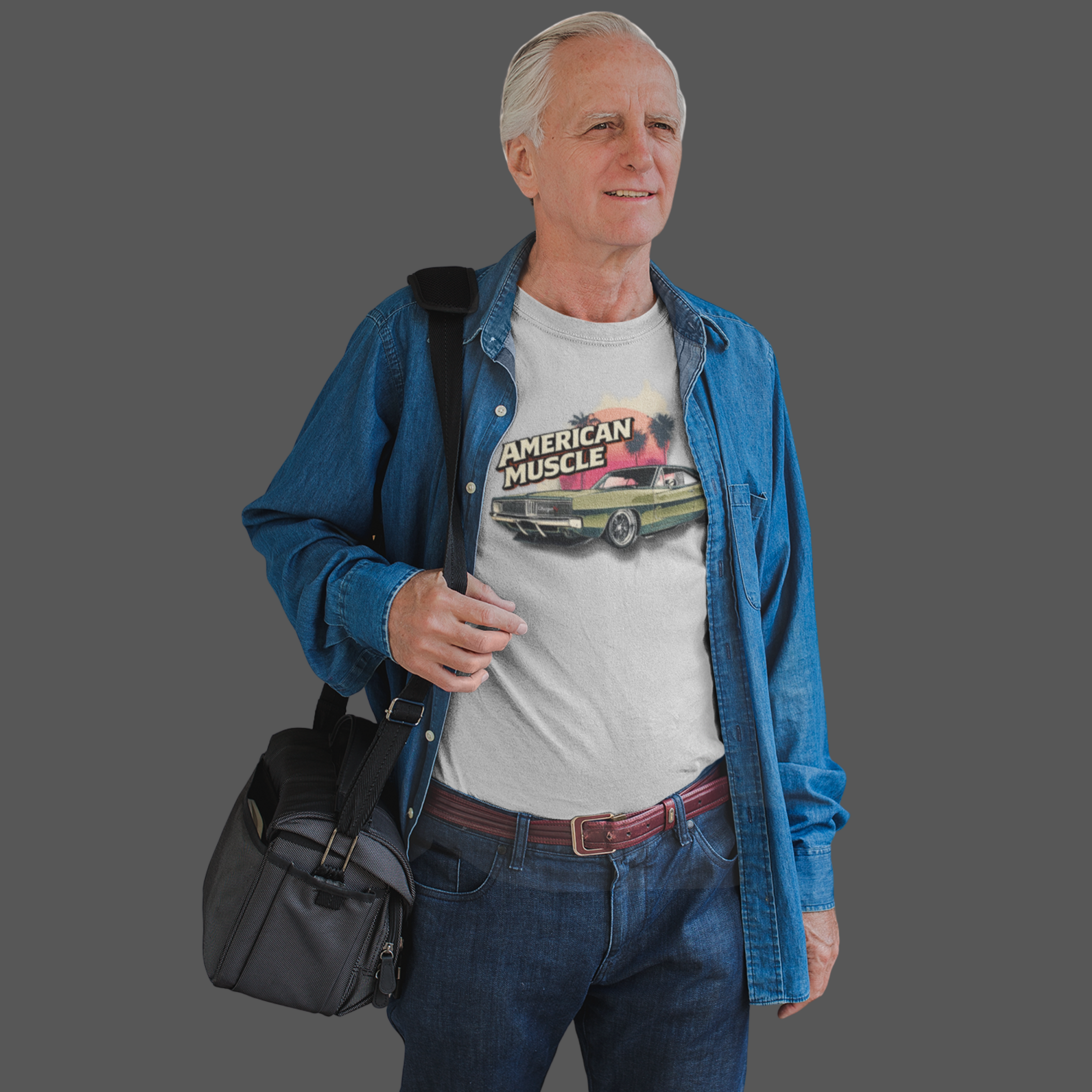 Man wearing a 'American Muscle' t-shirt with a blue jacket and carrying a black bag on a gray background