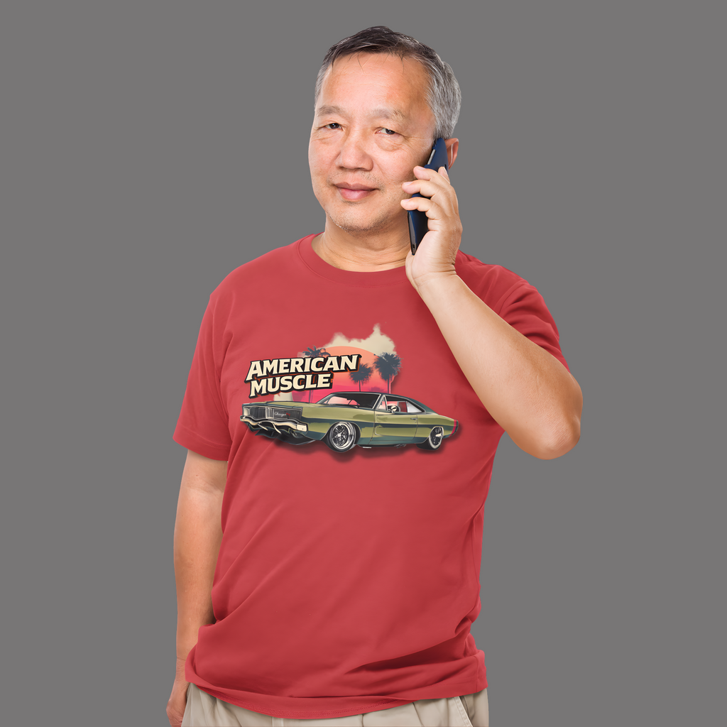 Man wearing a red t-shirt with 'American Muscle' graphic, talking on a phone against a gray background