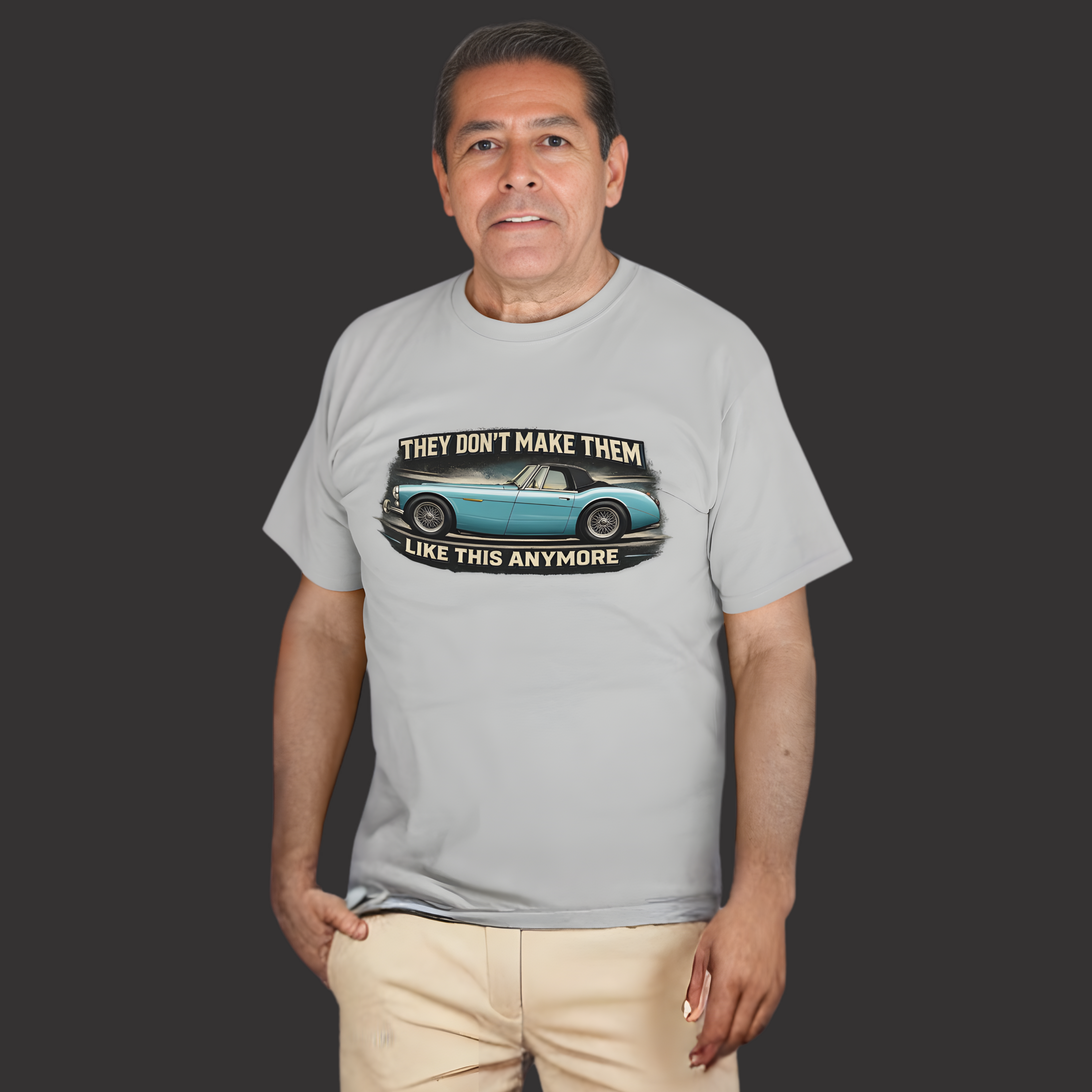 Man wearing a sport gray t-shirt with a Healey graphic design on a dark background