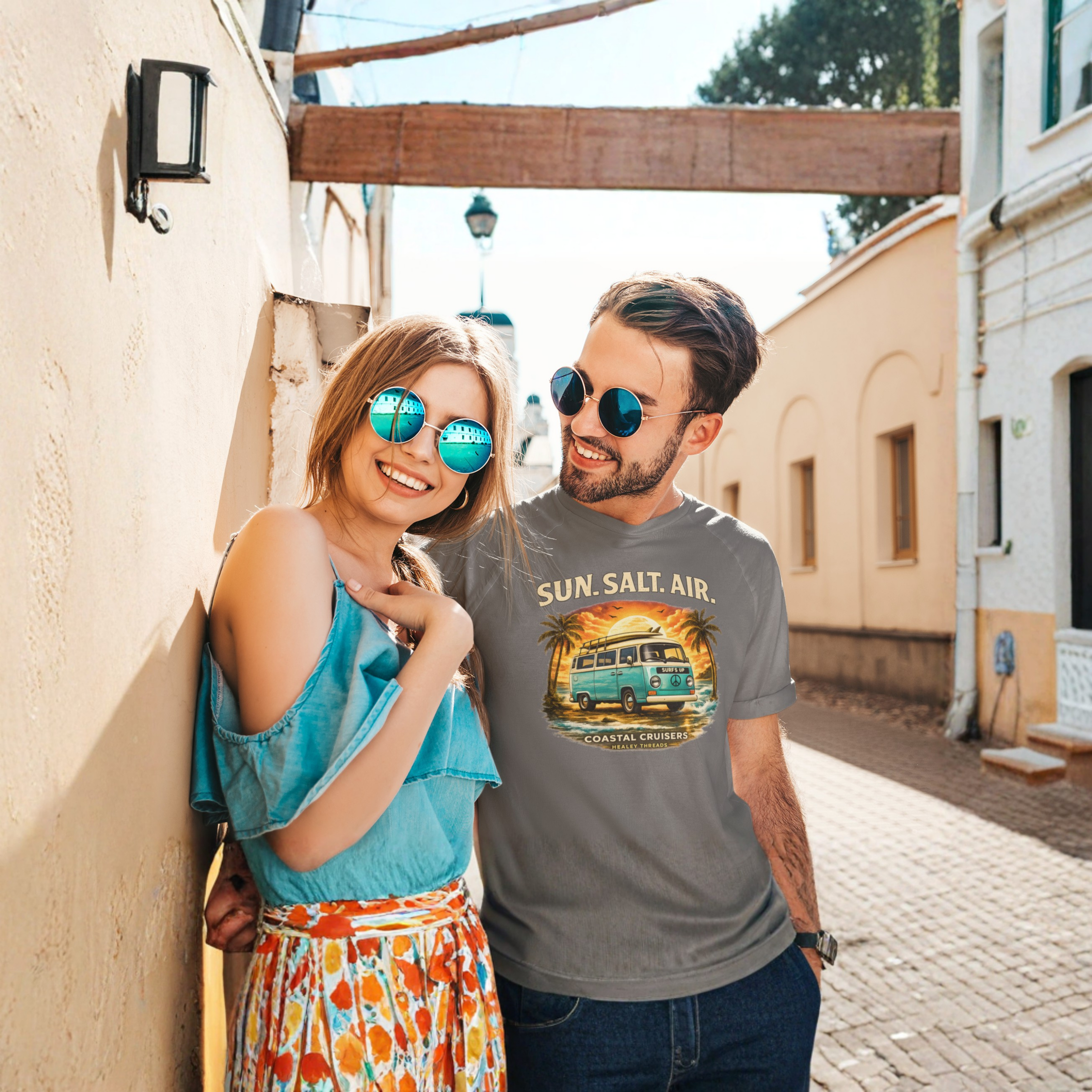 Two people standing together on a street, one wearing a t-shirt with a retro van graphic and text.