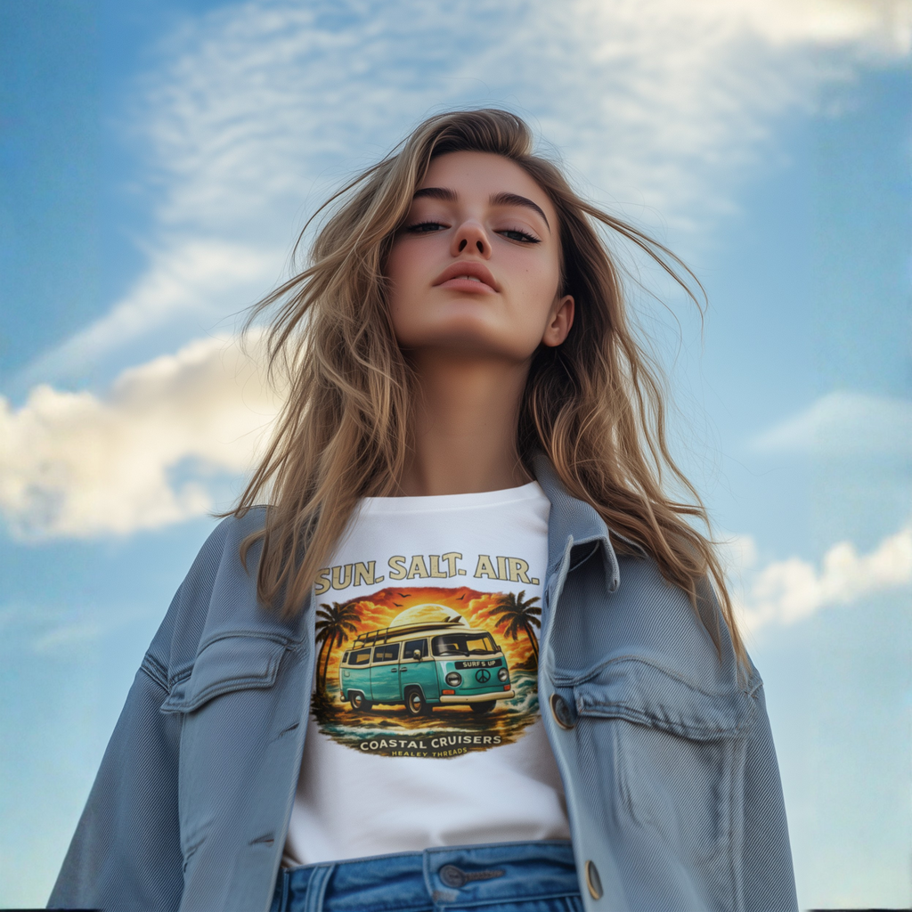 Woman wearing a t-shirt with a graphic retro van  design against a blue sky.