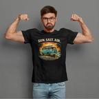 Man wearing a black t-shirt with a graphic retro van design and text, flexing his muscles against a gray background