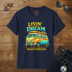 Navy blue t-shirt with a colorful van graphic and 'Livin' the Dream' text on a wooden surface.