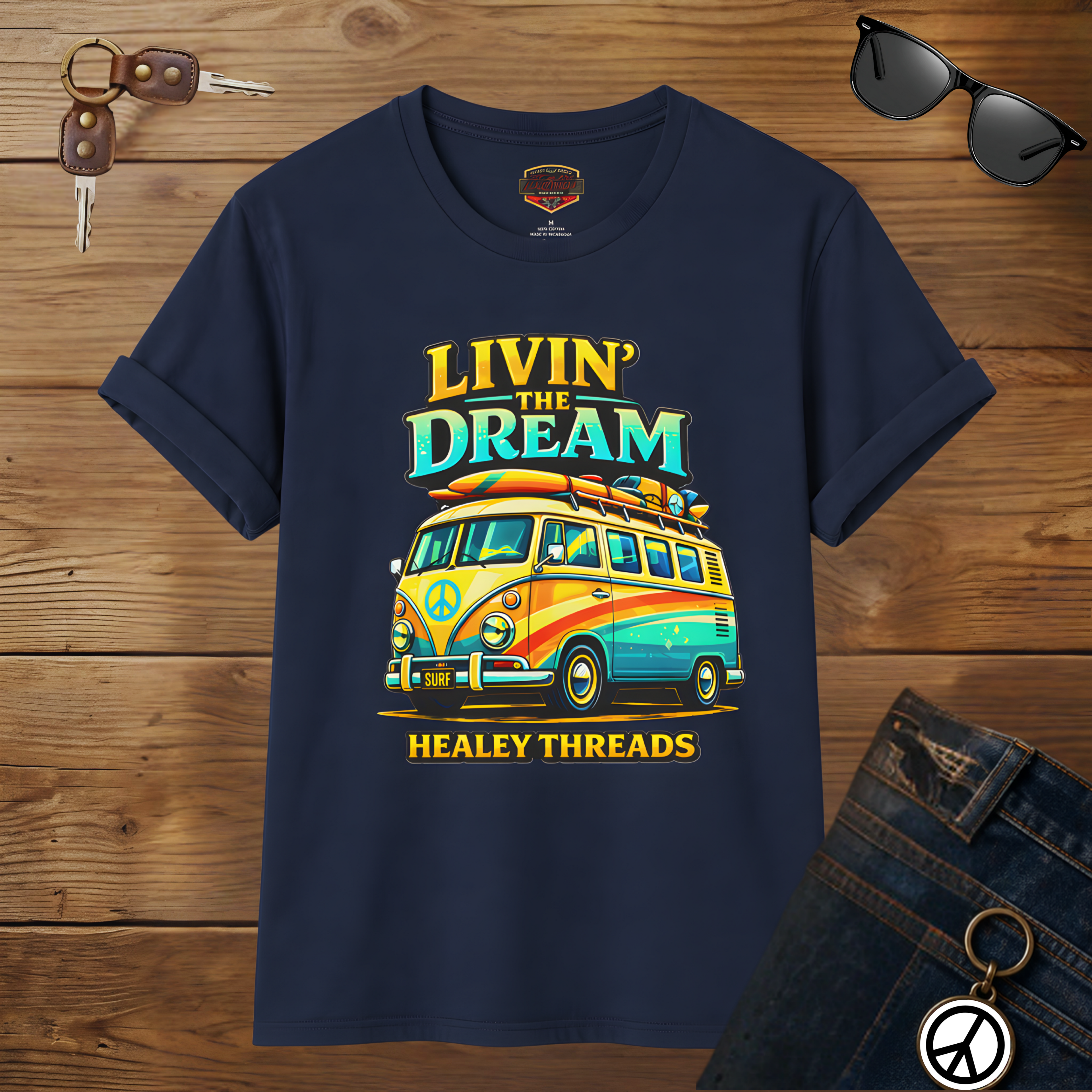 Navy blue t-shirt with a colorful van graphic and 'Livin' the Dream' text on a wooden surface.