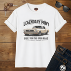White t-shirt with car graphic and text on a wooden surface with sunglasses and keys.