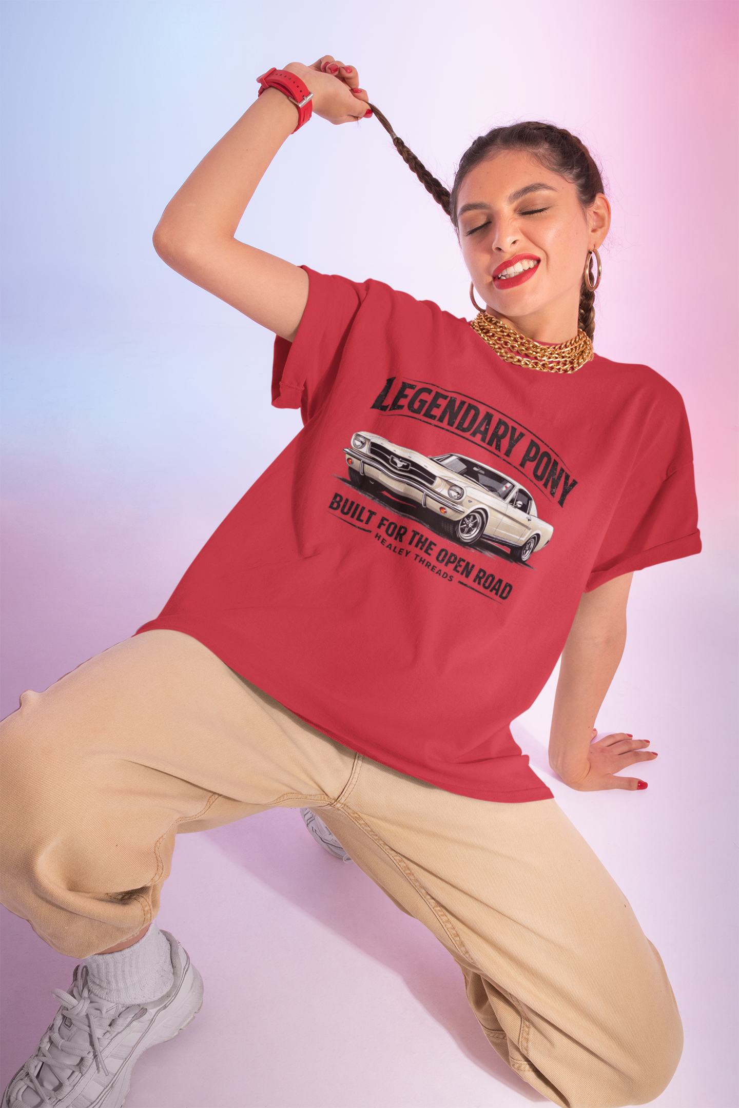 Woman wearing a red t-shirt with a classic car graphic and text, posing against a gradient background.