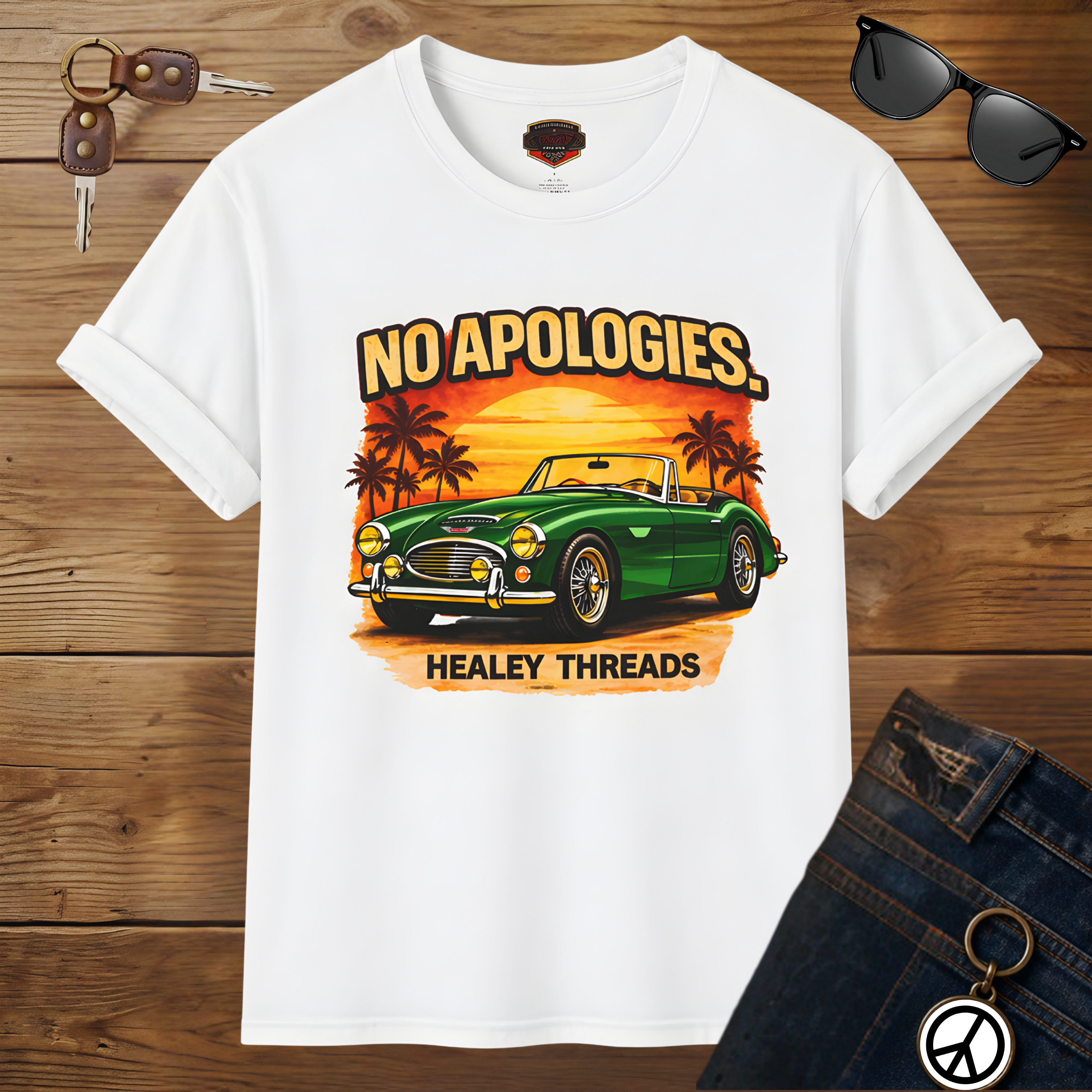 White t-shirt with a green classic car graphic and 'No Apologies' text on a wooden surface.