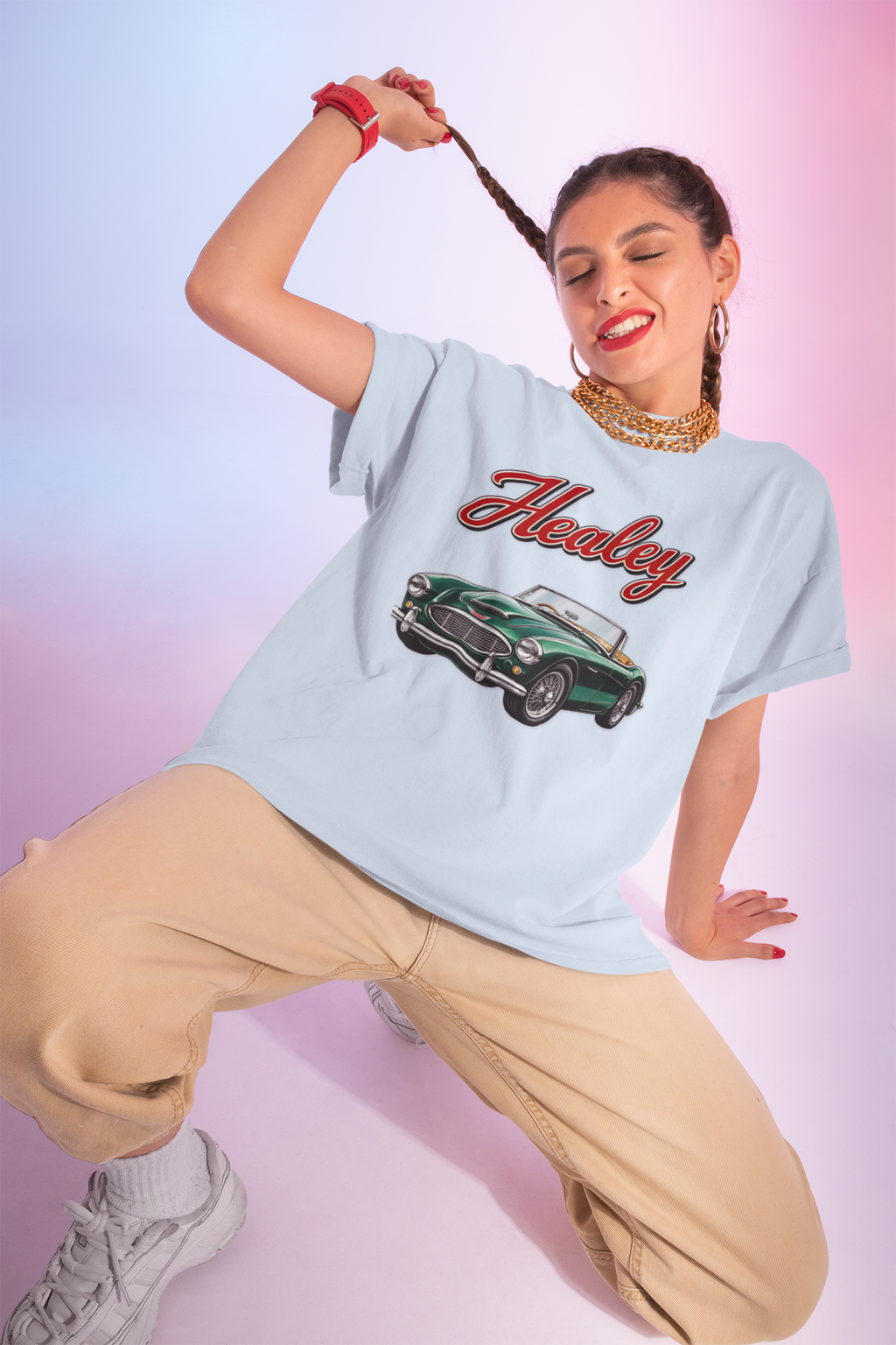 Woman wearing a light blue t-shirt with a classic car graphic and 'Healey' text on a gradient background