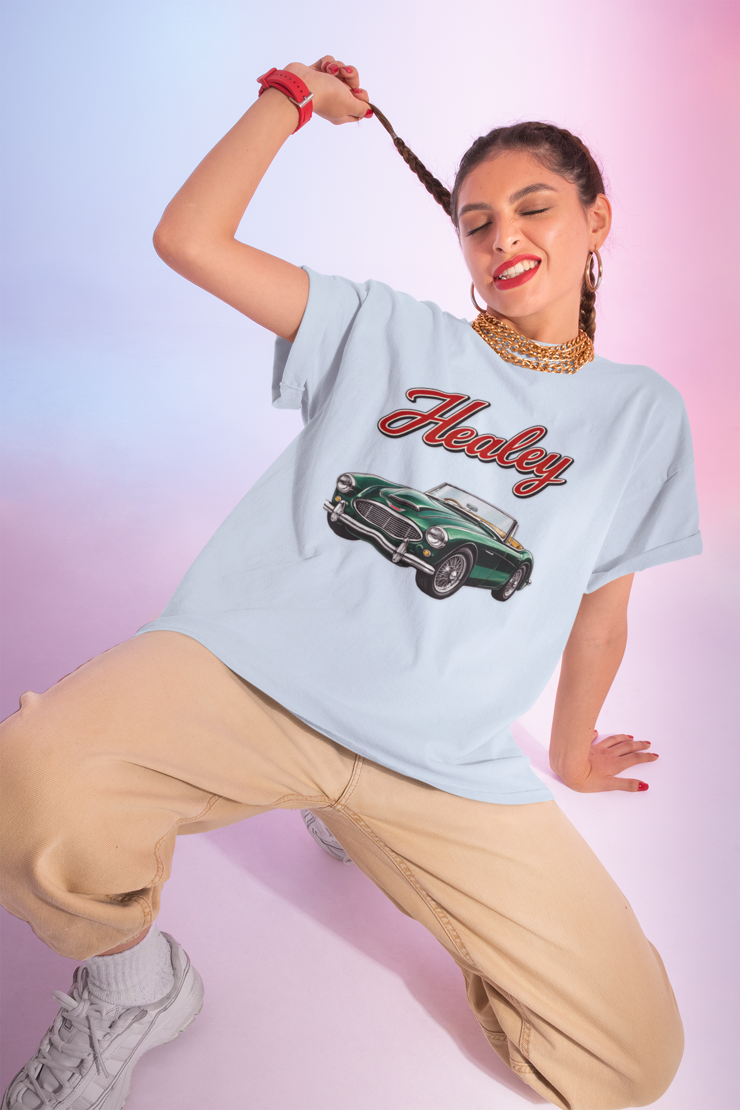 Woman wearing a light blue t-shirt with a classic car graphic and 'Healey' text on a gradient background