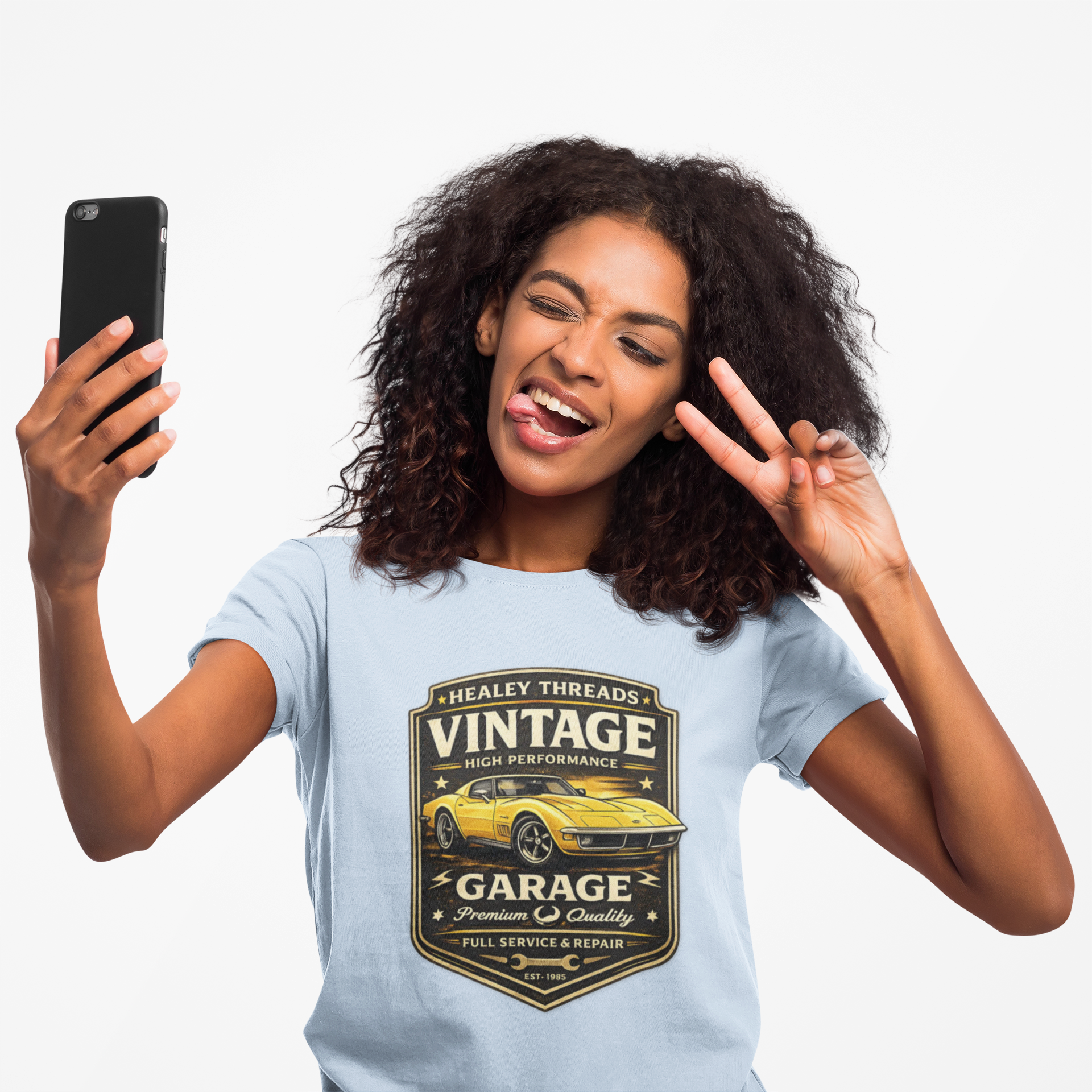 Woman wearing a light blue t-shirt with a vintage classic car graphic, taking a selfie.