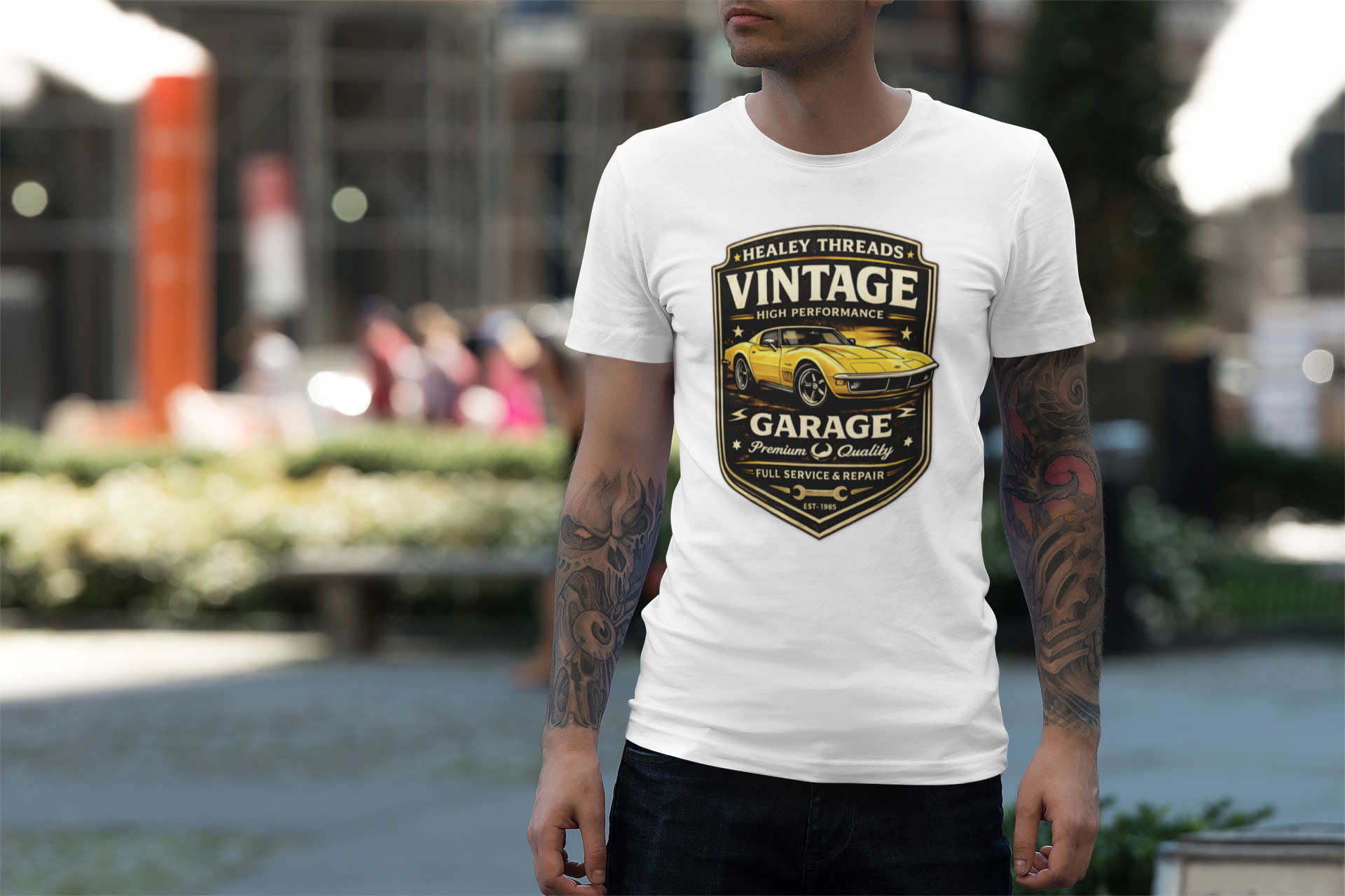 Man wearing a white t-shirt with a vintage classic car graphic design outdoors.