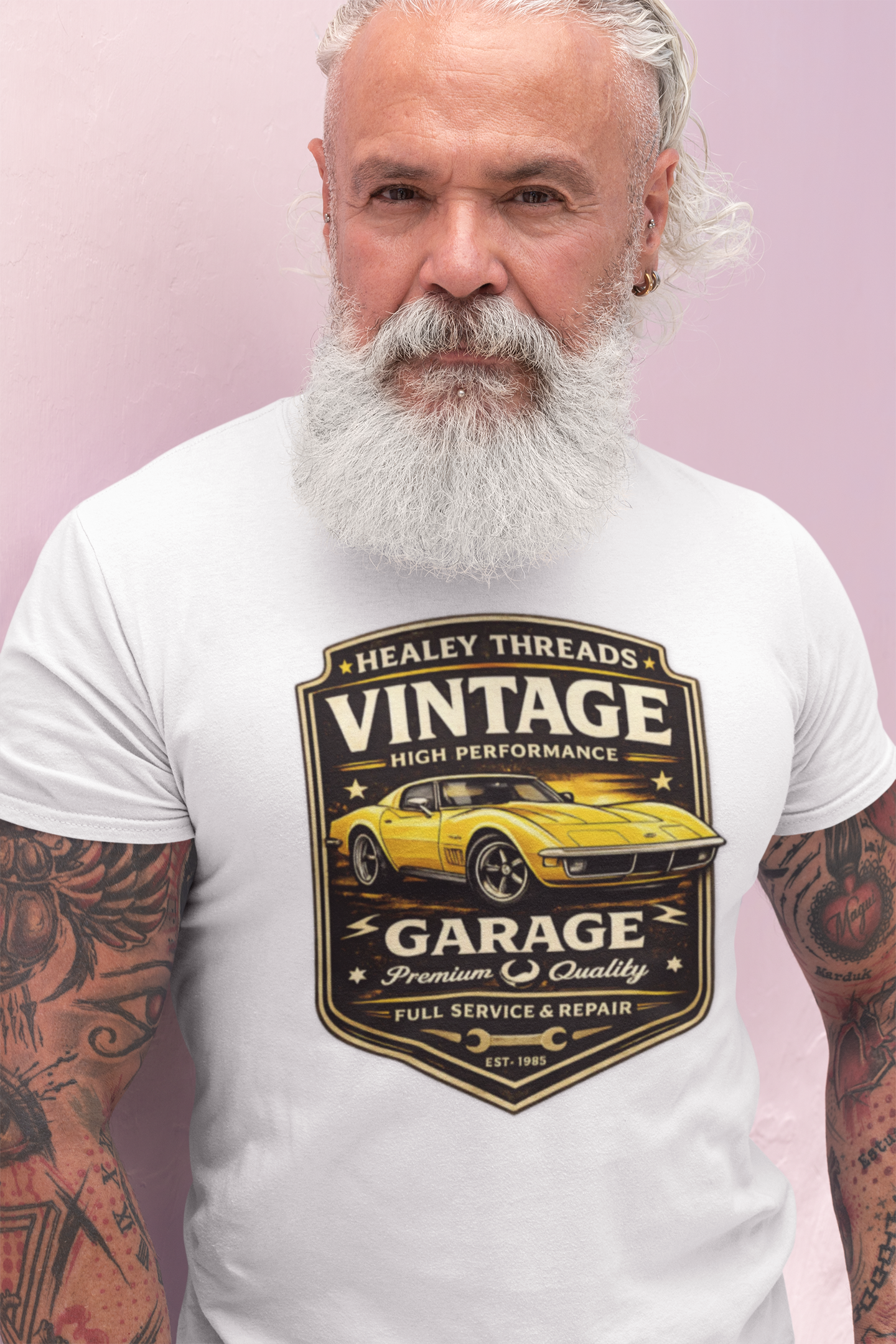 Man wearing a white t-shirt with a vintage classic car graphic design on a pink background