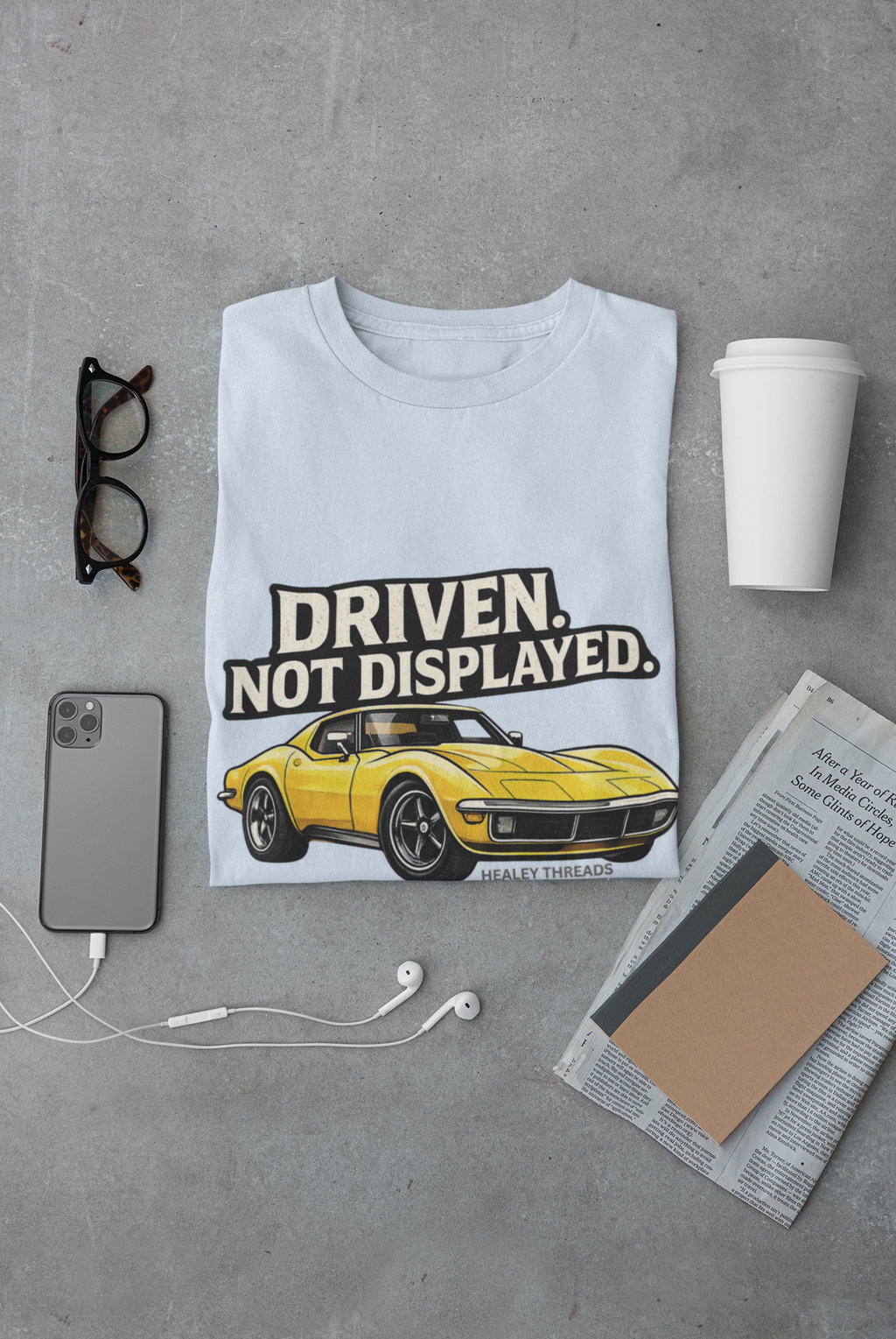 Light blue t-shirt with a yellow muscle car graphic and text 'Driven. Not Displayed.