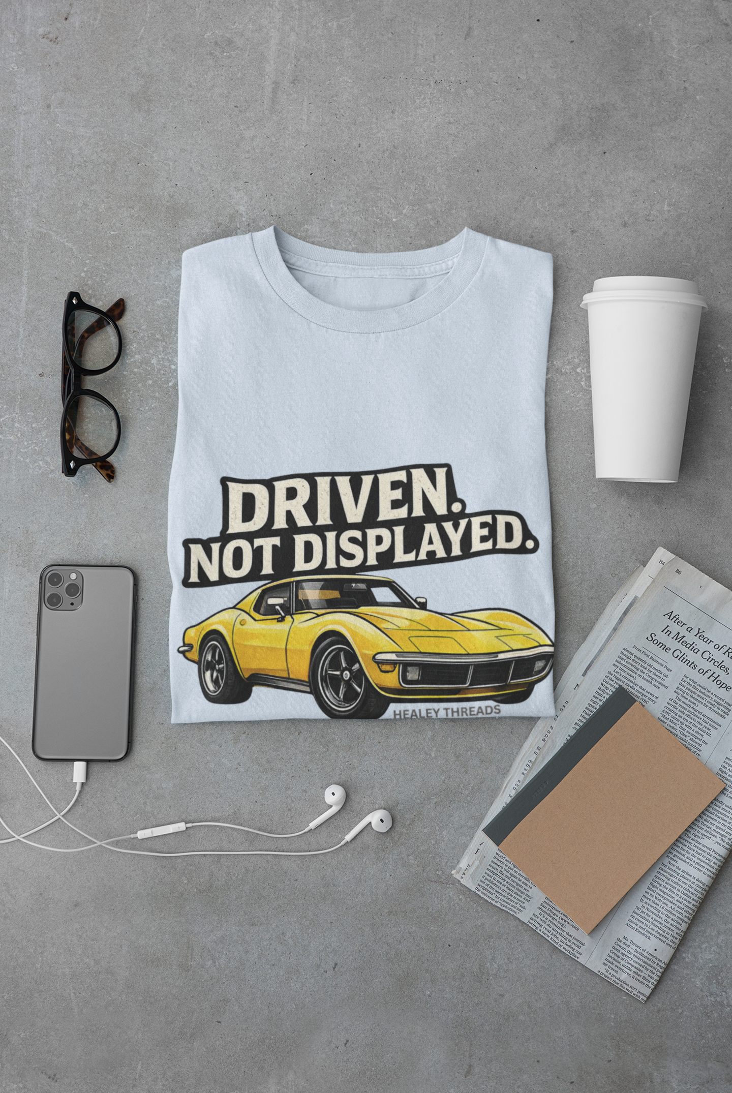 Light blue t-shirt with a yellow muscle car graphic and text 'Driven. Not Displayed.