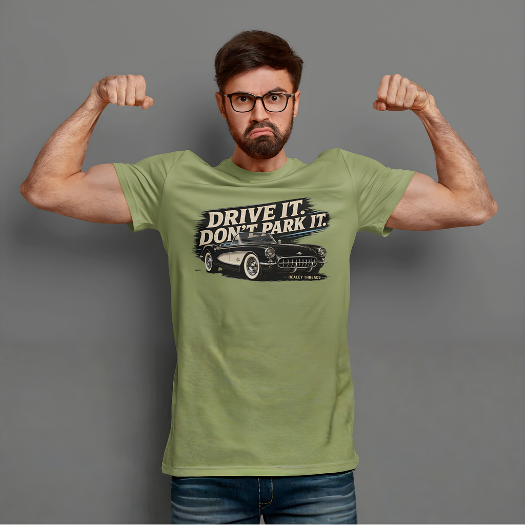 Man wearing a military green t-shirt with a vintage car graphic and text, flexing his muscles against a gray background