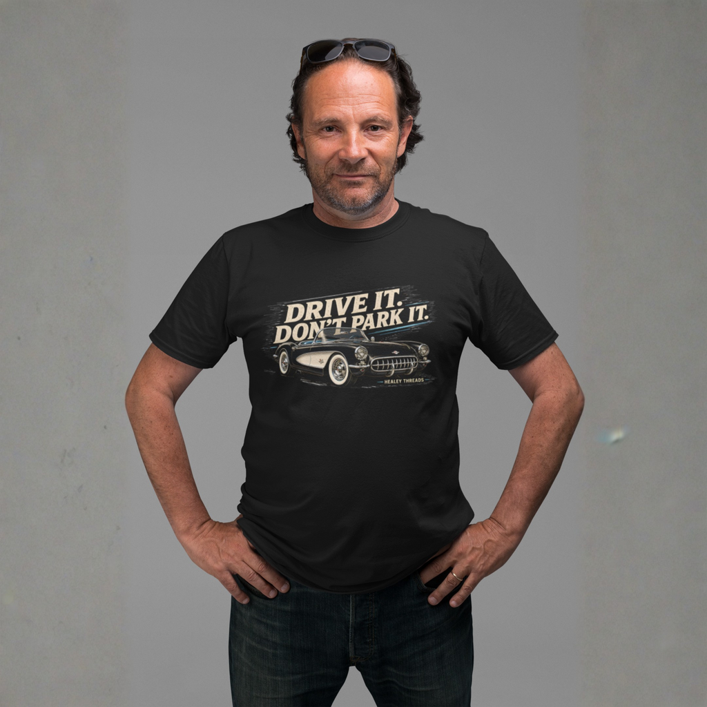 Man wearing a black t-shirt with a vintage car graphic and text against a gray background