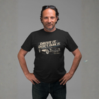 Man wearing a black t-shirt with a vintage car graphic and text against a gray background