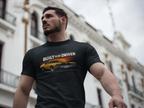 Man wearing a black t-shirt with a car built to be driven graphic and text, standing in front of a building.