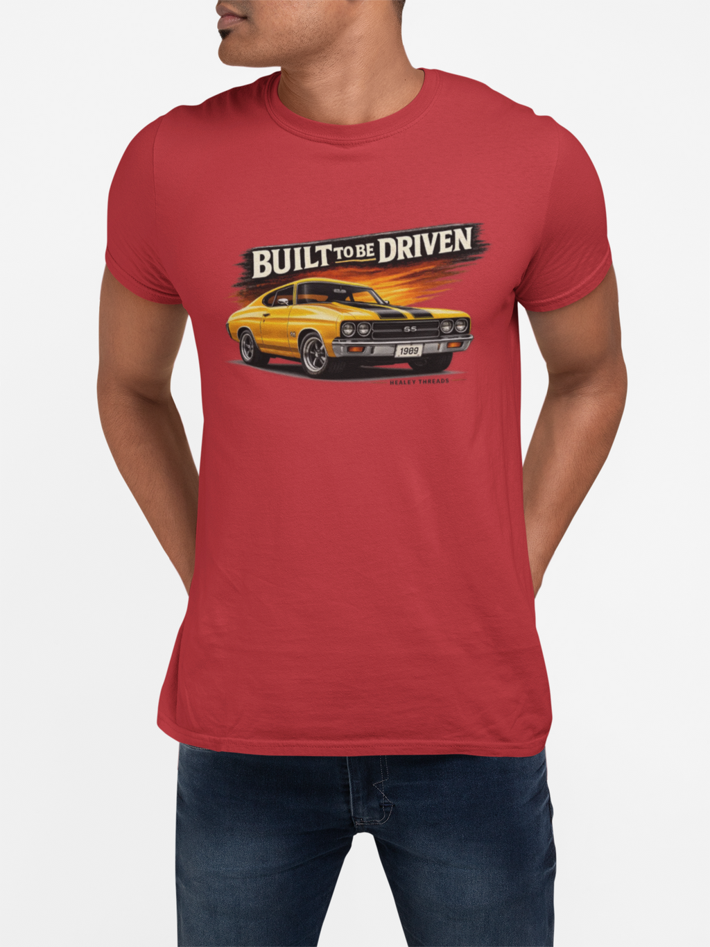 Red t-shirt with a graphic of a yellow car and 'Built to be Driven' text worn by a person on a white background