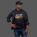 Man wearing a black t-shirt with a graphic car design and text, standing against a gray background