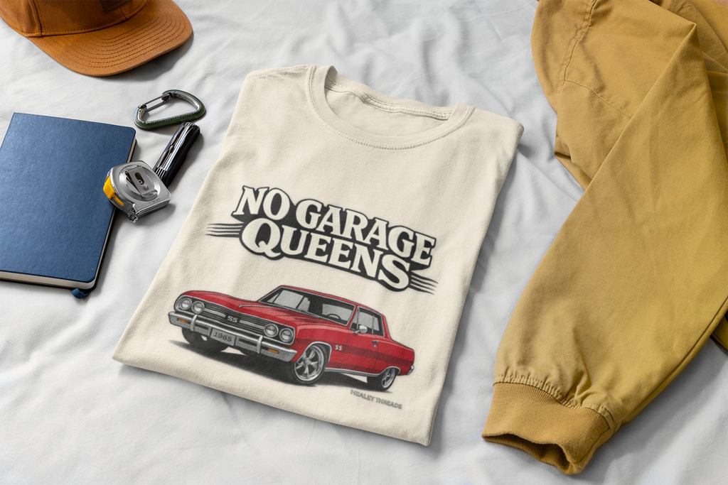 Natural t-shirt with 'No Garage Queens' graphic on a white surface with accessories.