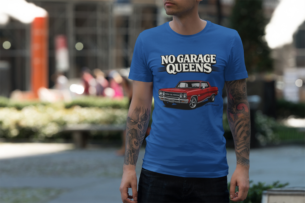 Man wearing a royal blue t-shirt with 'No Garage Queens' graphic in an outdoor setting
