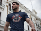 Man wearing a navy blue t-shirt with a circular Healey Sprite graphic design in an urban setting