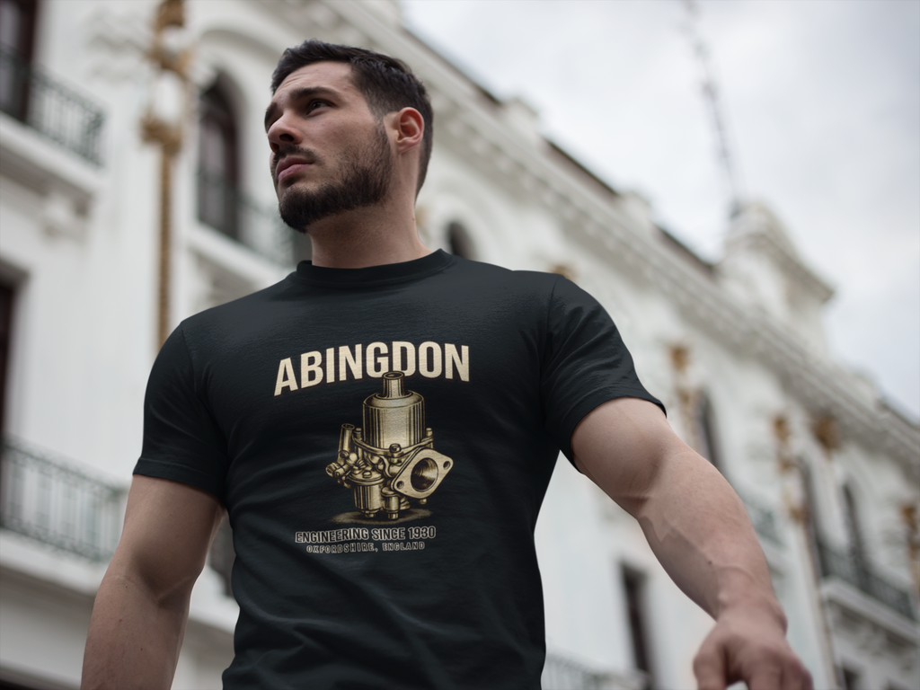 Man wearing a black t-shirt with 'Abingdon' and engine graphic, standing in front of a building.