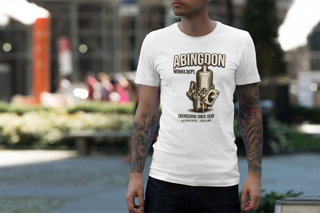 Man wearing a white t-shirt with 'Abingdon' graphic design graphic design outdoors.