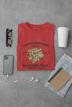 Red t-shirt with coventry engine graphic and text on a gray surface with accessories.