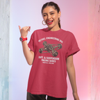 Woman wearing a red t-shirt with engineering graphic and text, pointing to the side.