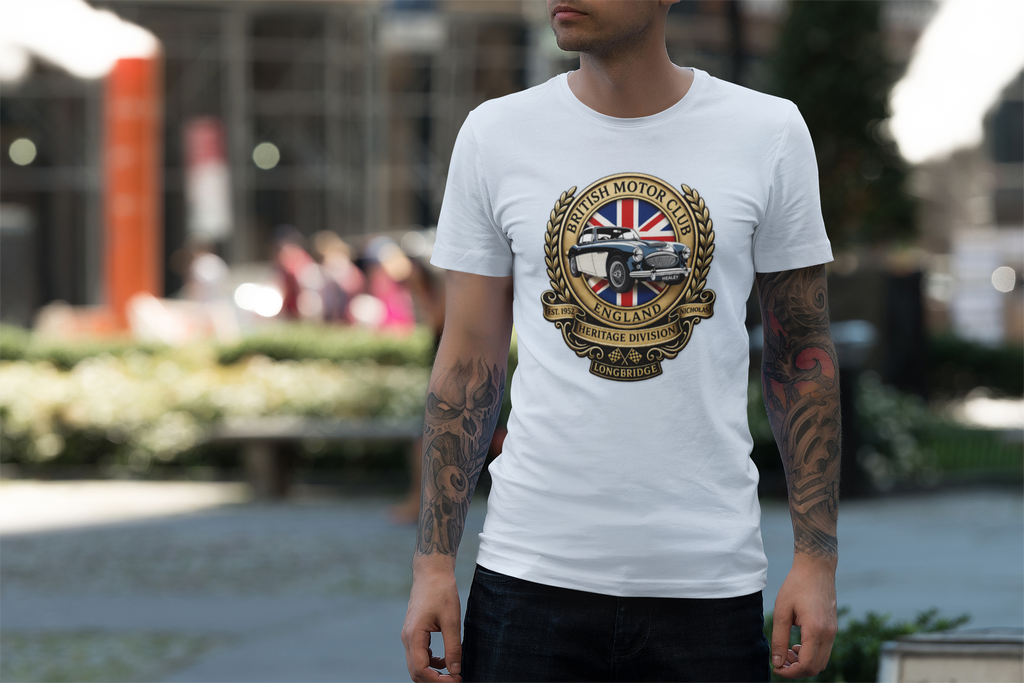 Man wearing a white t-shirt with a British motor vehicle logo in an outdoor setting