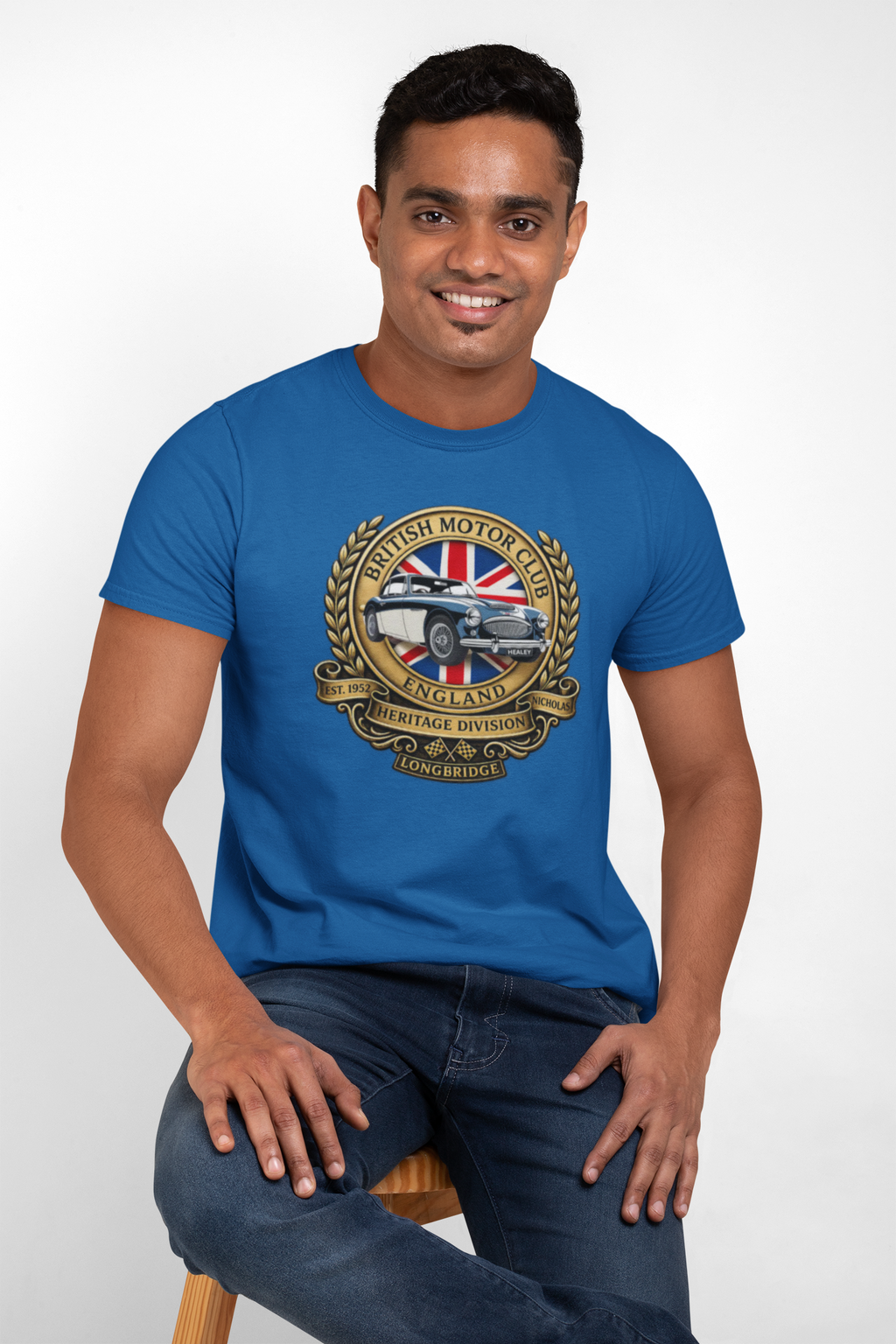 Man wearing a royal blue t-shirt with a British Motor Heritage logo on a white background
