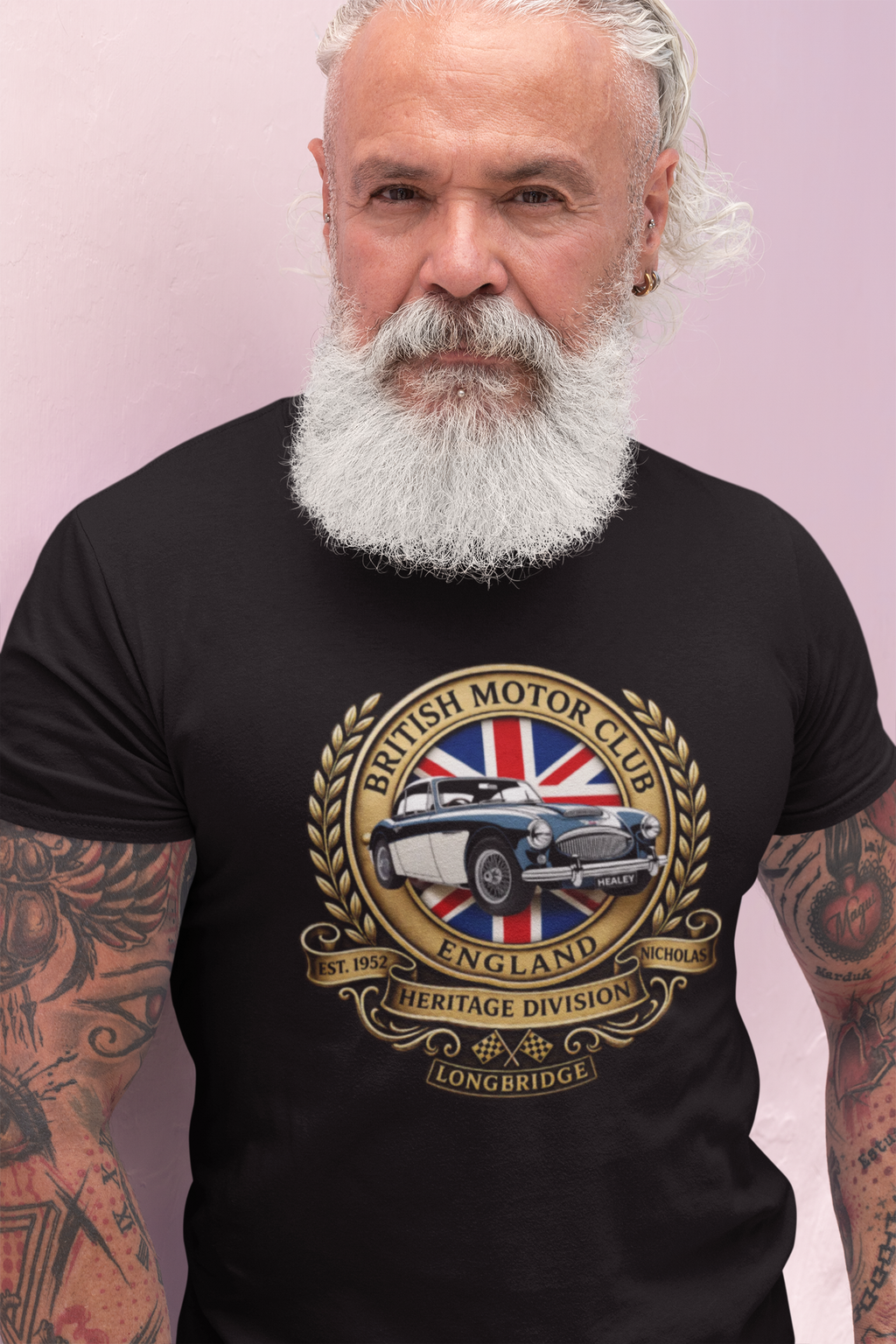 Man wearing a black t-shirt with a British Motor Club logo on a light purple background