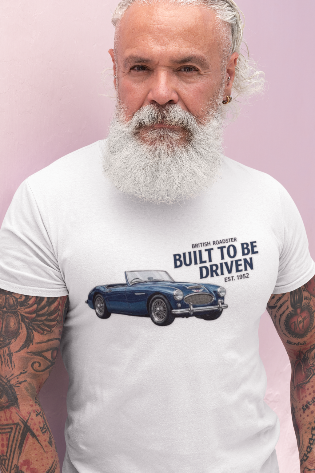 Man wearing a white t-shirt with a car design and text on a pink background