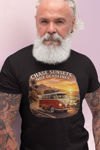 Man wearing a black t-shirt with a graphic red van design and text 'Chase Sunsets Not Deadlines' on a light pink background.