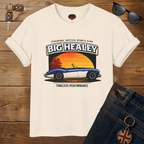 Big Healey graphic t-shirt featuring a blue and white Austin Healey roadster with retro sunset artwork and vintage British sports car typography on a wooden background.