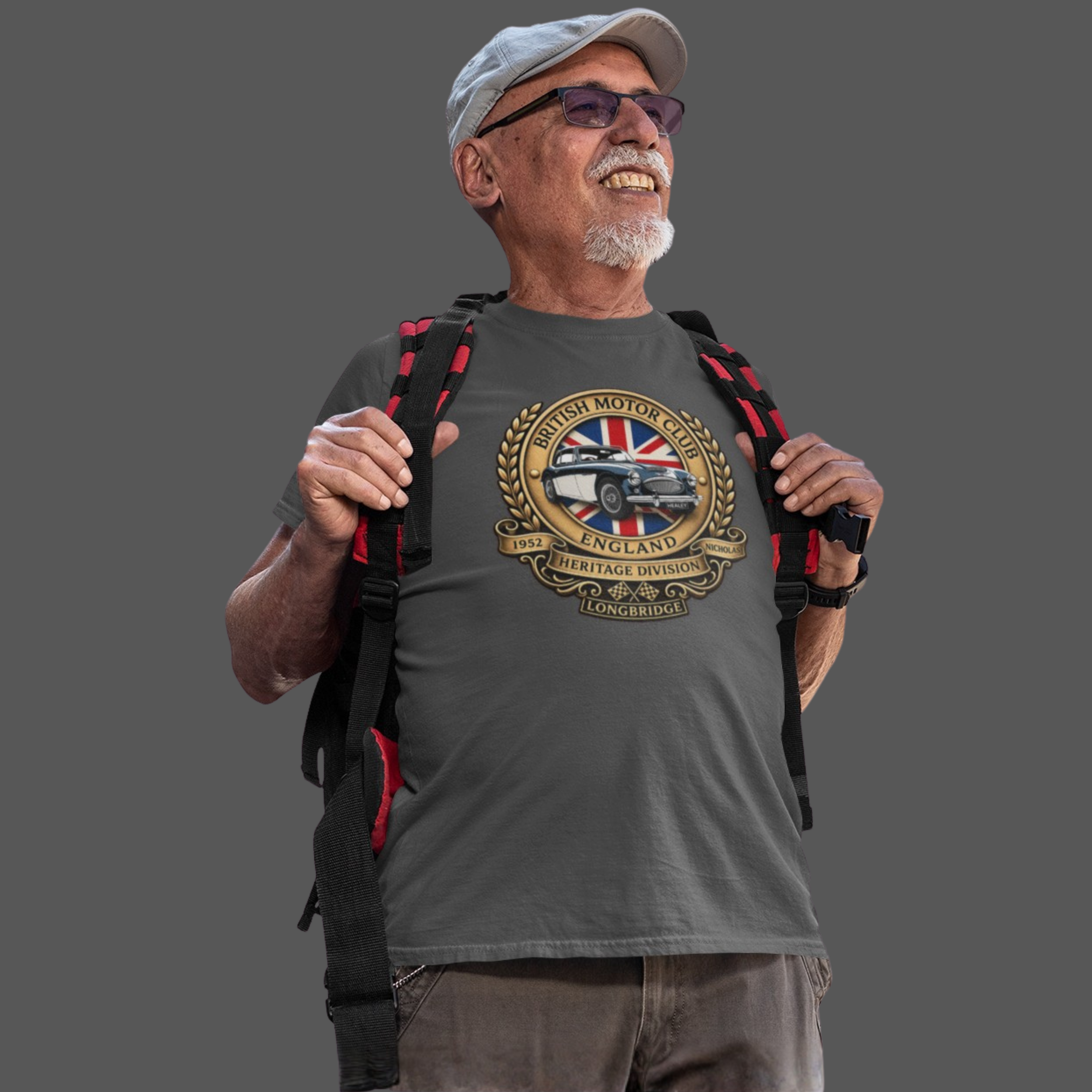 Man wearing a gray t-shirt with a British Motor Club logo and holding a backpack on a transparent background