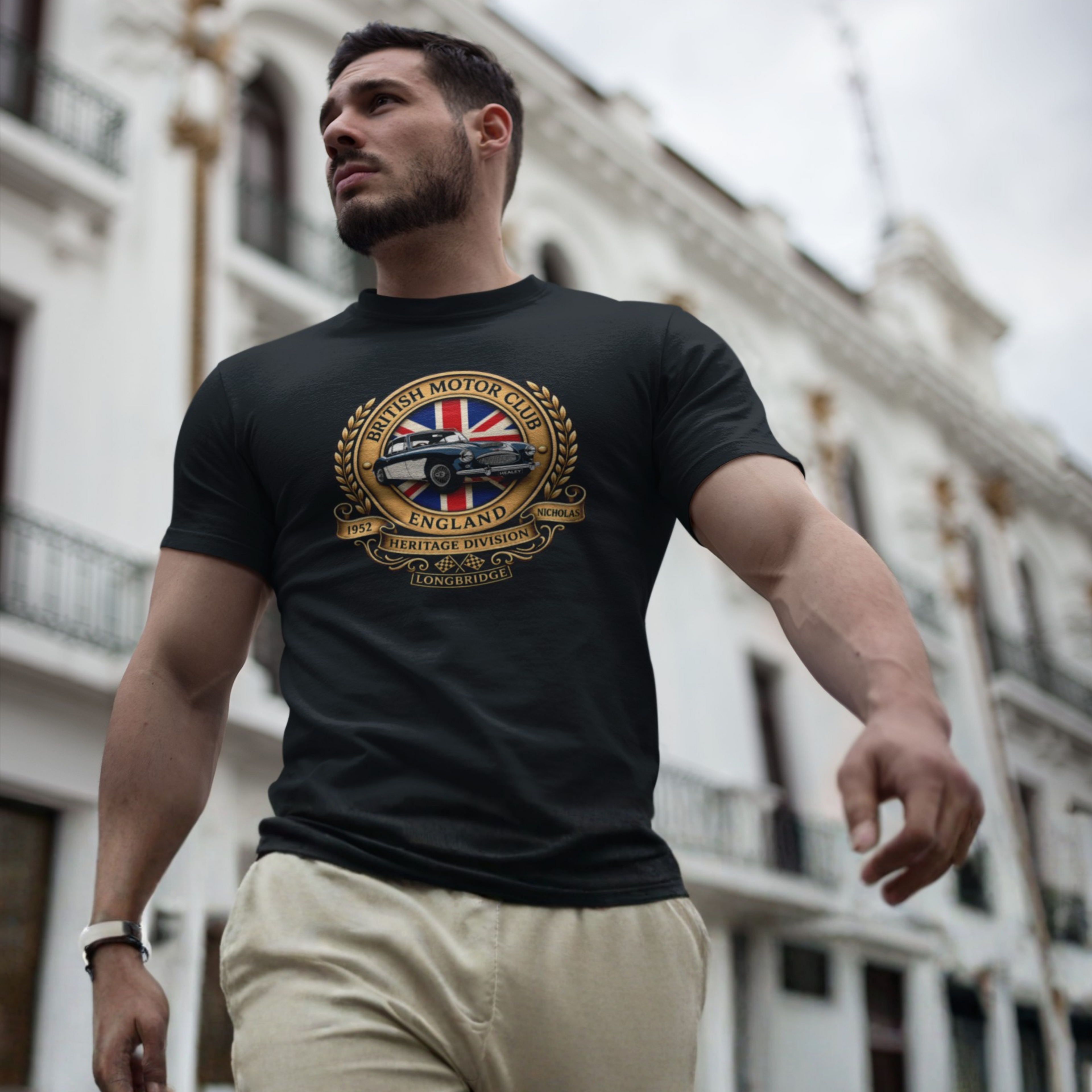 Man wearing a black t-shirt with a British Motor Club logo in an urban setting