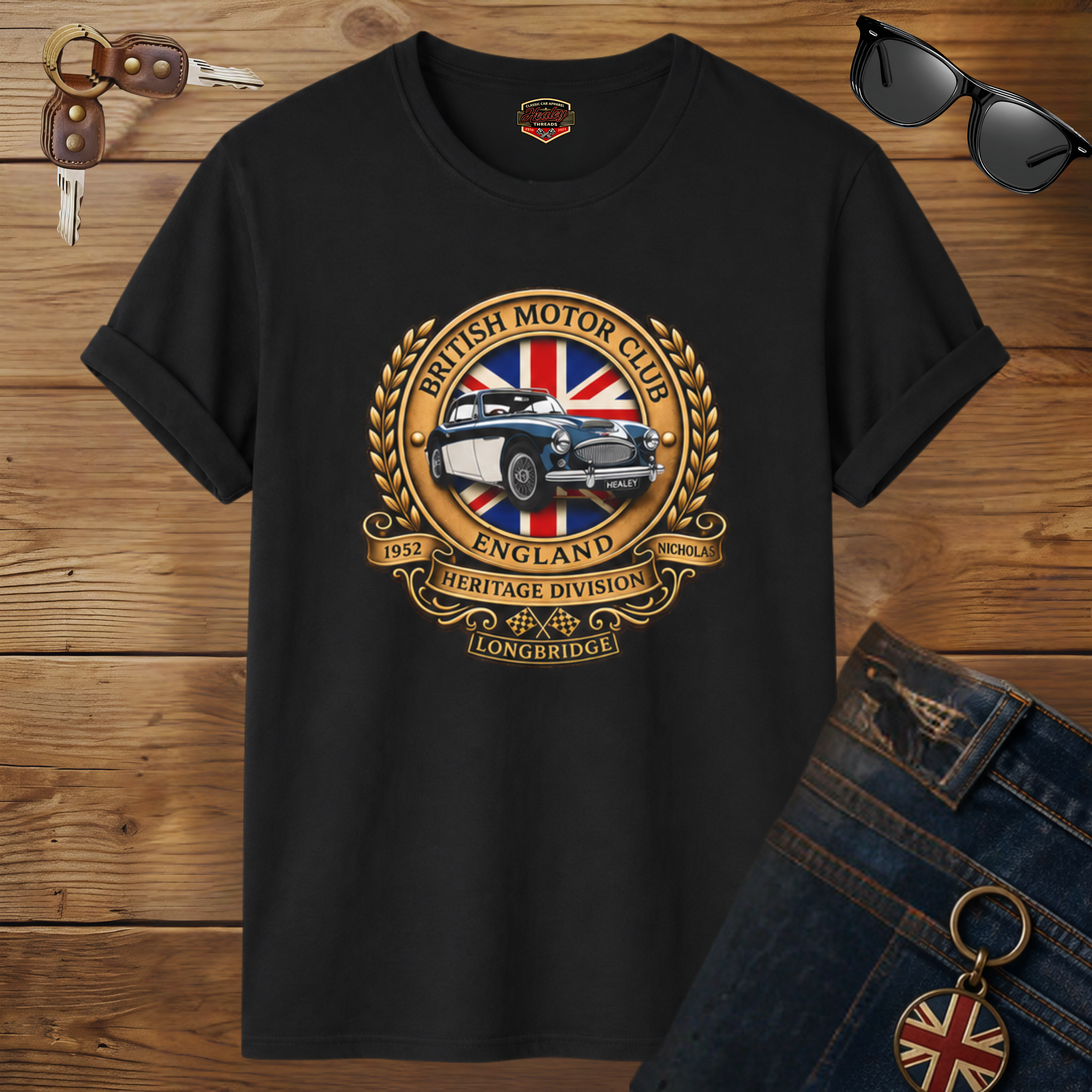 Black t-shirt with British Motor Club logo on a wooden surface with sunglasses and keys.
