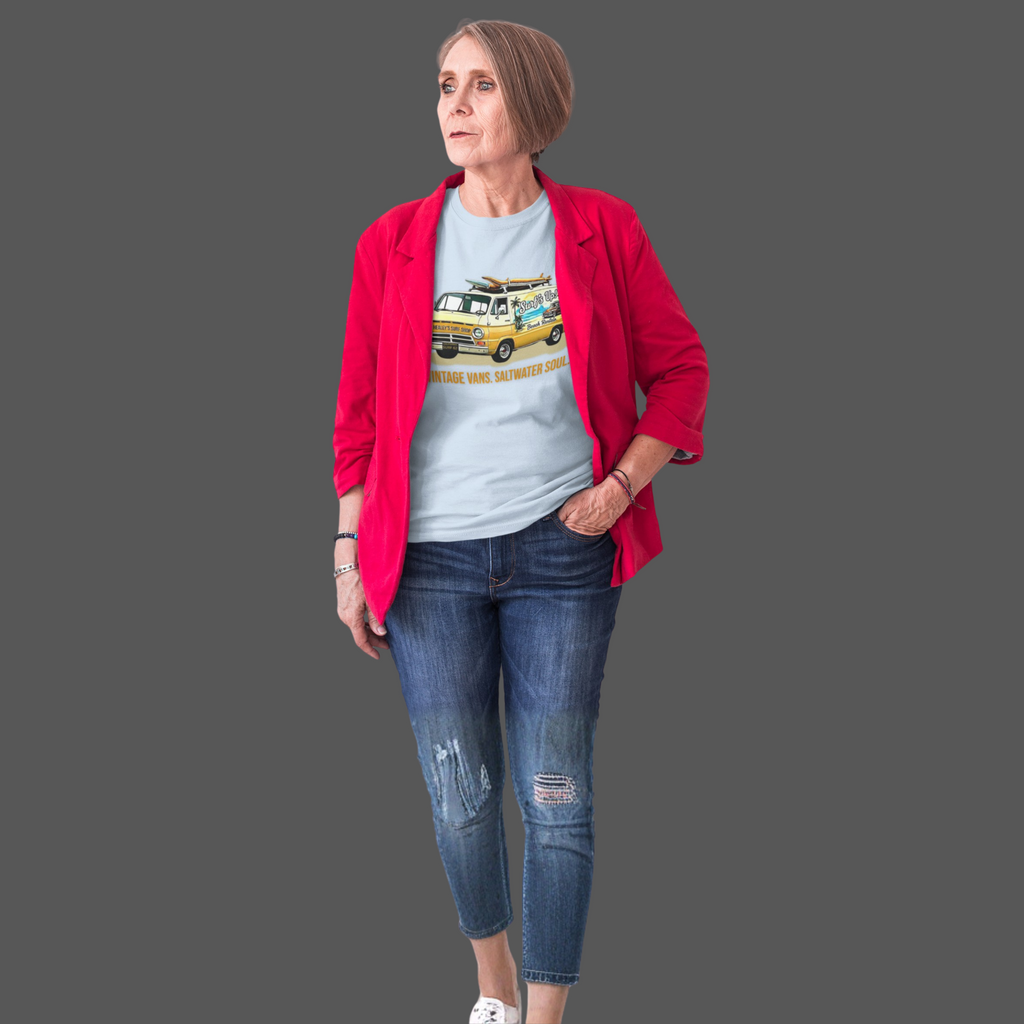 Woman wearing a red jacket, gray t-shirt with a classic van graphic, and blue jeans on a gray background