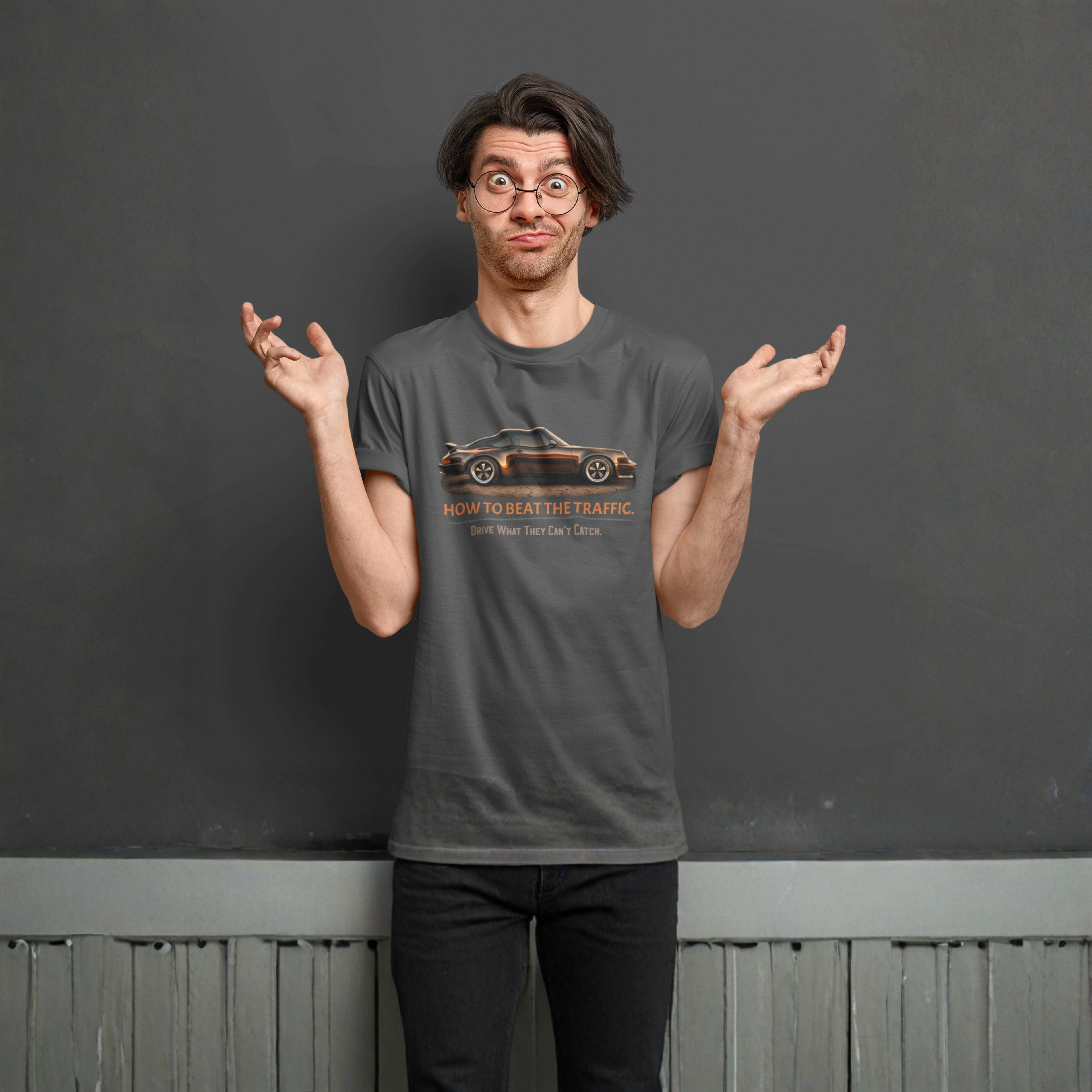 Man wearing a gray t-shirt with a classic car graphic and text, standing against a plain background