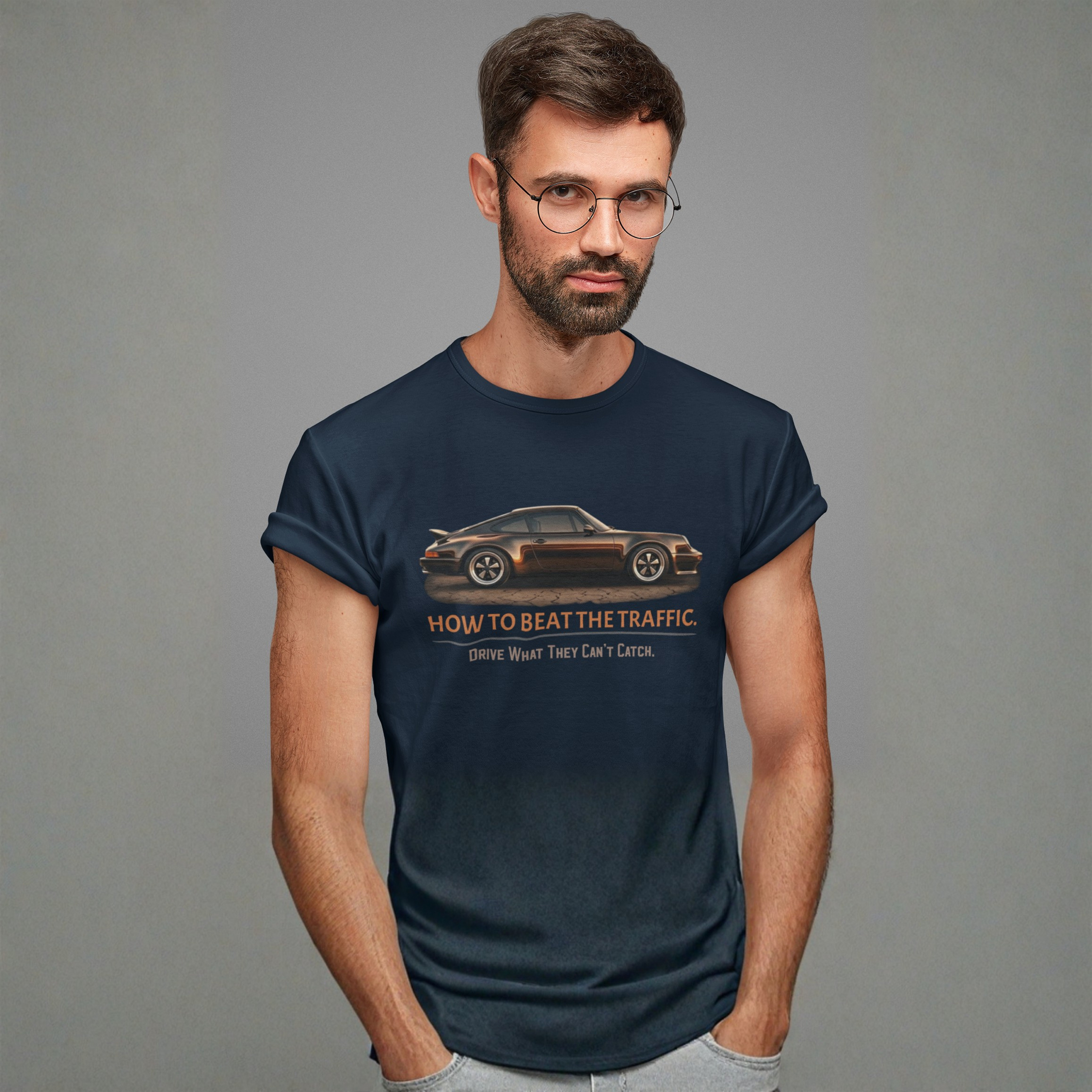 Man wearing a navy blue t-shirt with a classic car graphic design on a gray background