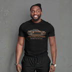 Man wearing a black t-shirt with a graphic car design and text on a gray background