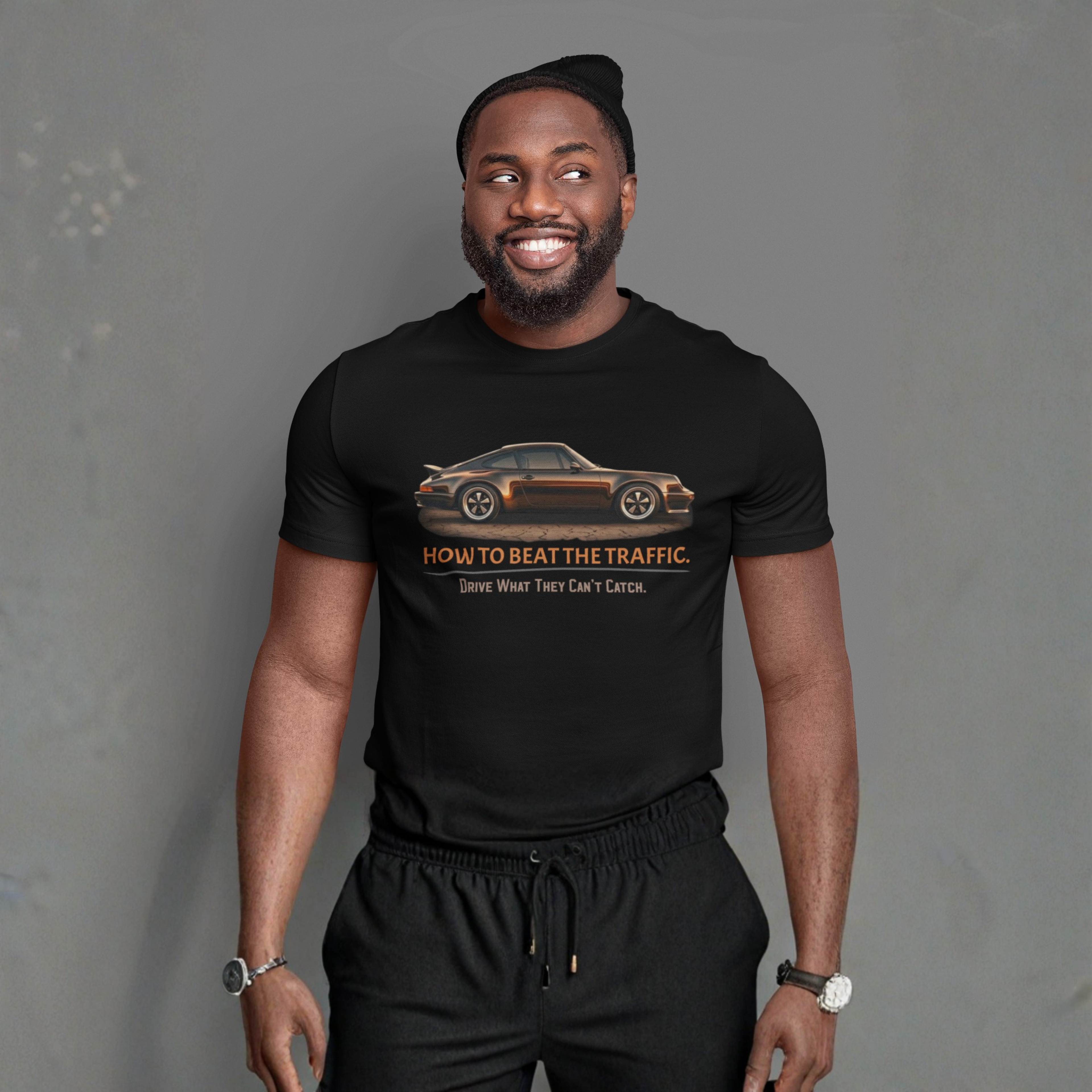 Man wearing a black t-shirt with a graphic car design and text on a gray background