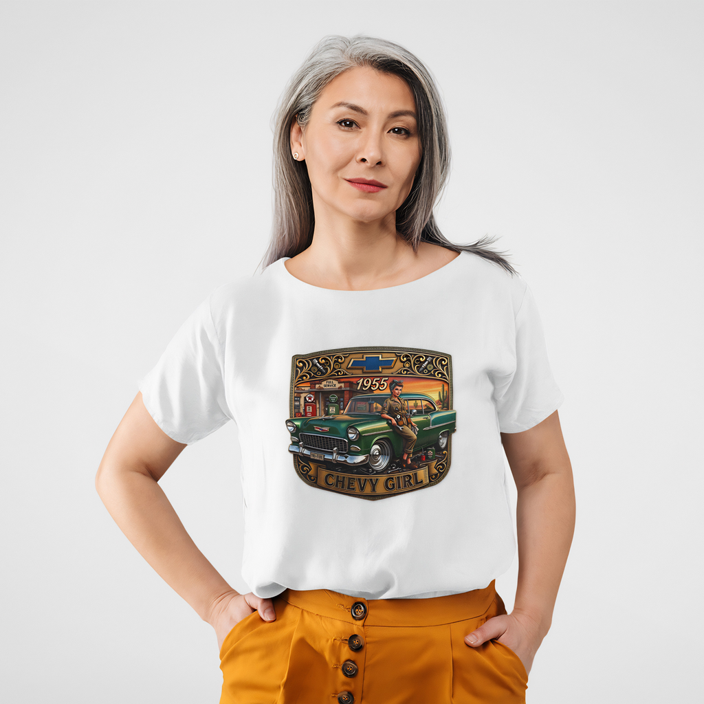 A woman modeling a white short-sleeve t-shirt with a vintage-style graphic print featuring a green classic car and the text 'CHEVY GIRL' and '1952'. She is wearing mustard yellow pants against a clean, light gray studio background.