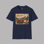 A navy blue short-sleeve crewneck t-shirt featuring a vintage-style 'Happy Canada Day!' graphic print on the front, showing a red car and Canadian flags, displayed against a solid gray background.